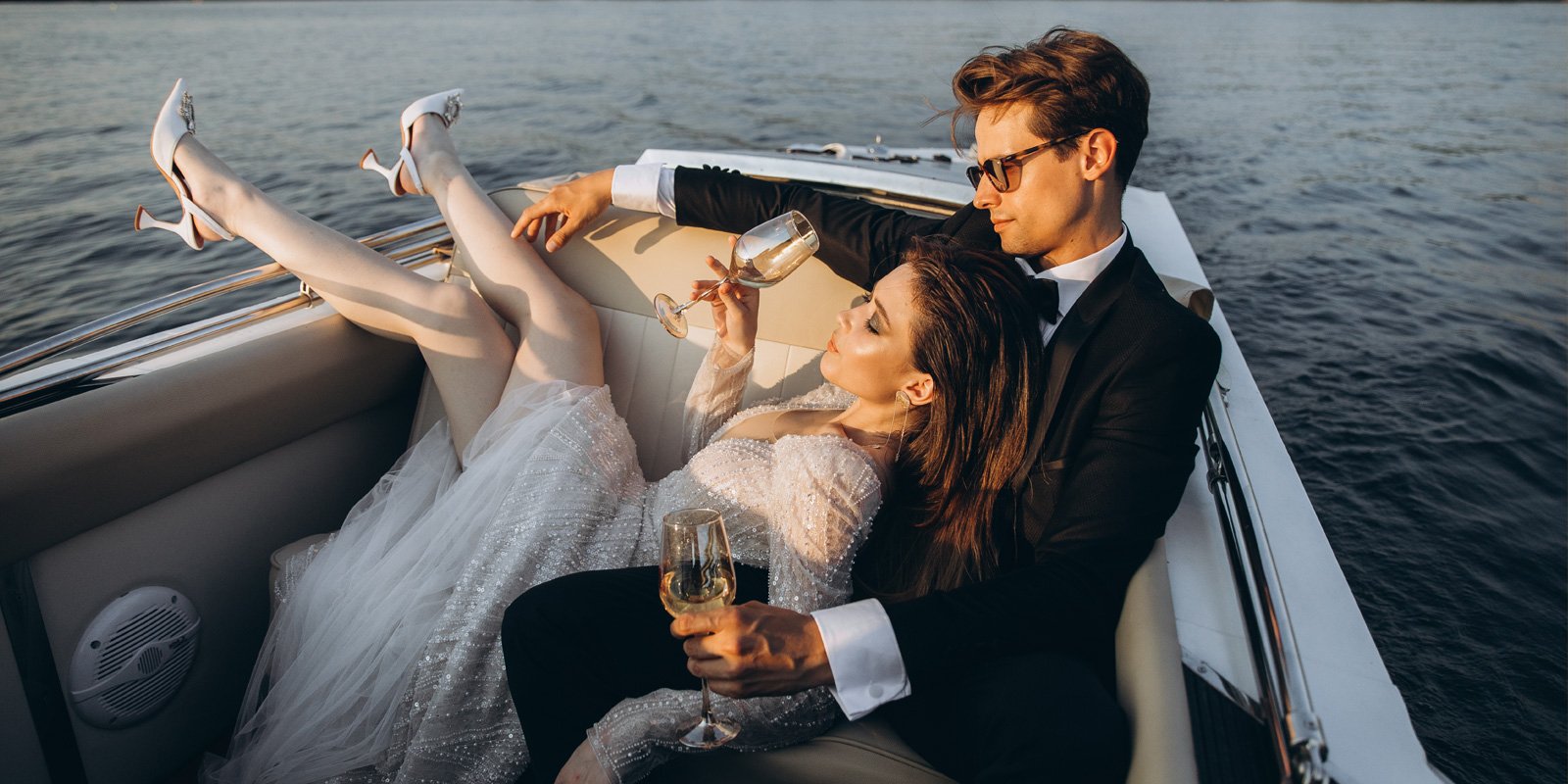 Glamorous man and woman on a boat with glasses of wine